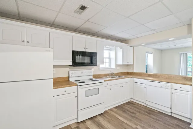 a kitchen with white cabinets sink and white appliances