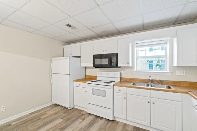 a kitchen with white cabinets and white appliances