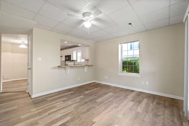 an empty room with wooden floor and windows