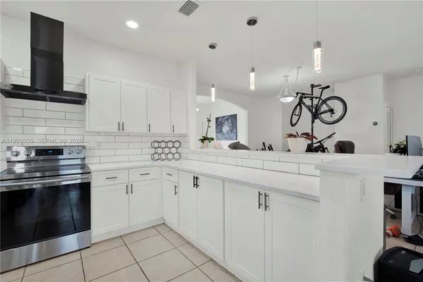 a kitchen with white cabinets a sink and stainless steel appliances