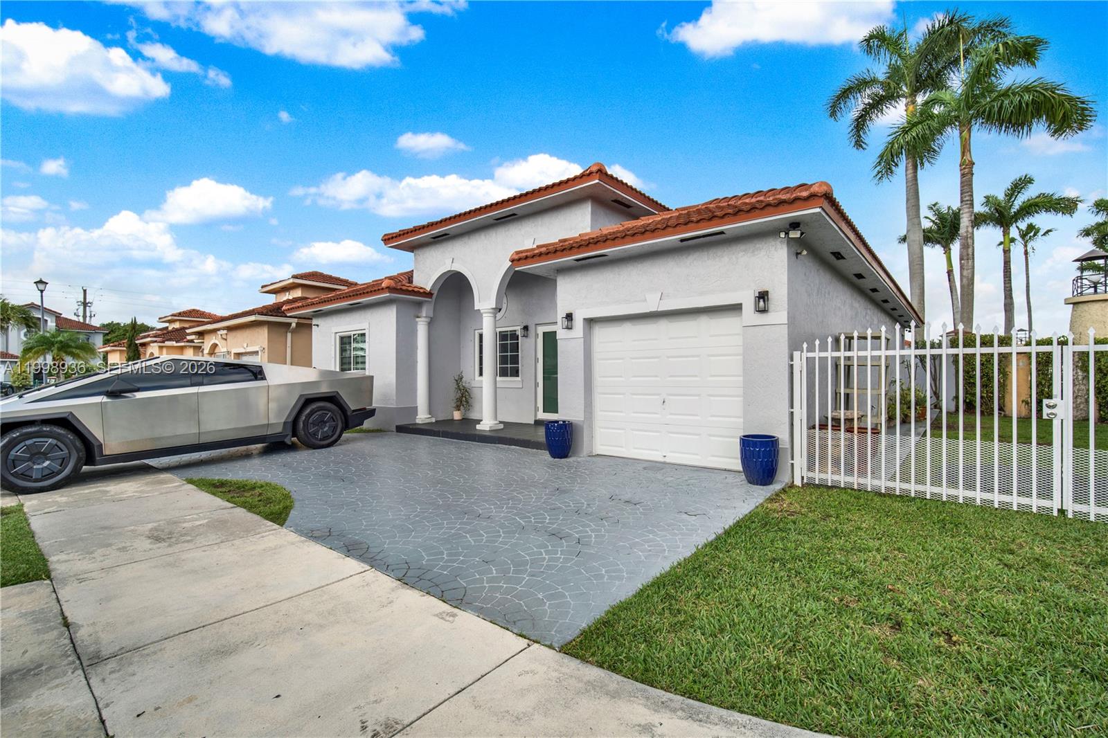 5510 Southwest 161st Place Miami, FL 33185 - Photo 2 of 28 a view of a white house with a small yard plants and a large tree