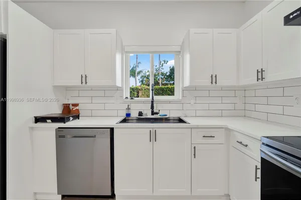 a kitchen with granite countertop a sink and cabinets