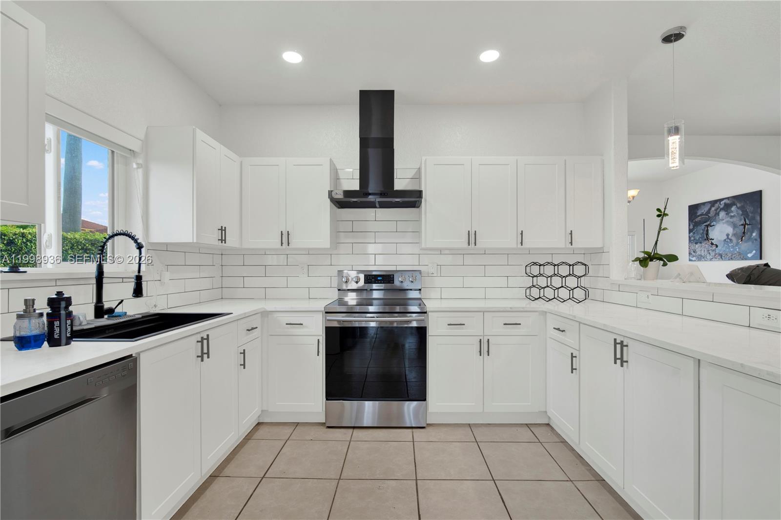 5510 Southwest 161st Place Miami, FL 33185 - Photo 10 of 28 a kitchen with a sink stove and cabinets