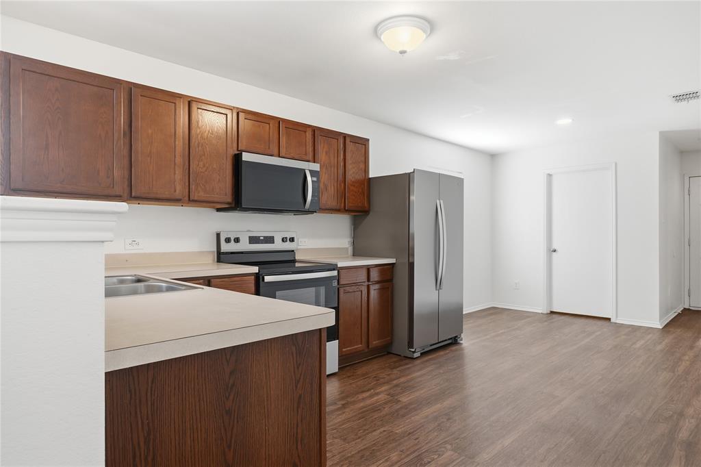 4005 Freedom Street Forney, TX 75126 - Photo 14 of 40 a kitchen with a refrigerator stove and microwave