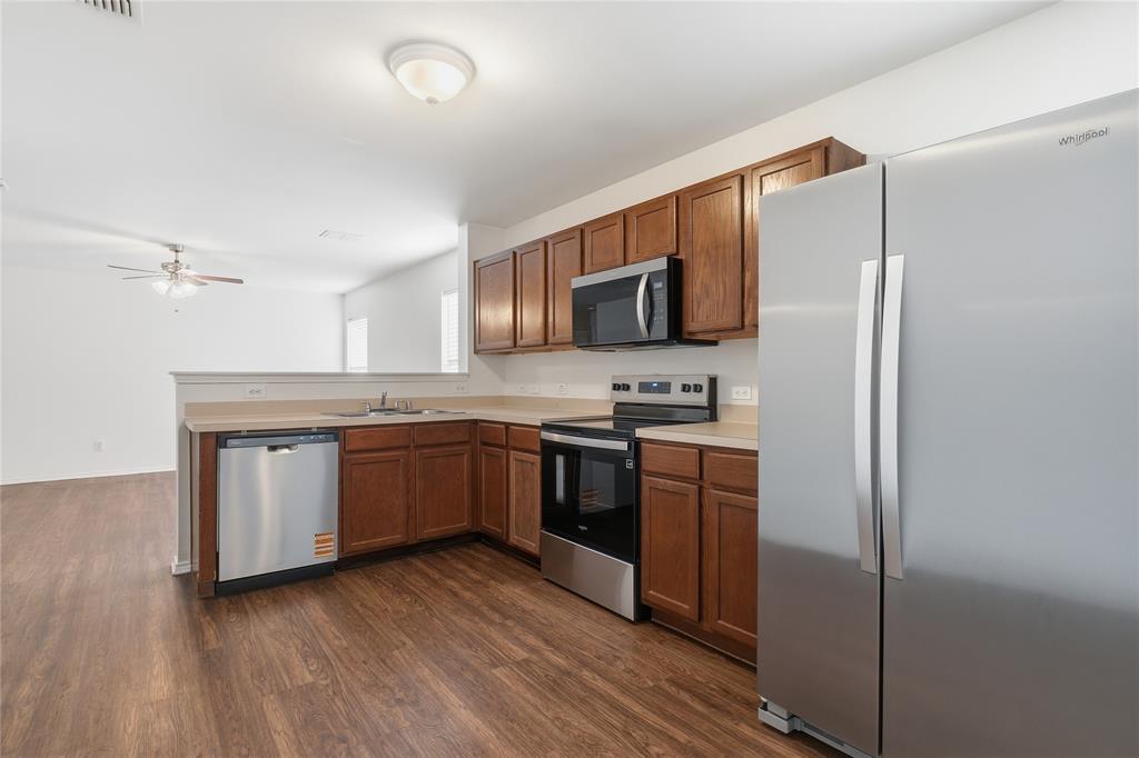 4005 Freedom Street Forney, TX 75126 - Photo 16 of 40 a kitchen with stainless steel appliances granite countertop a refrigerator stove and sink