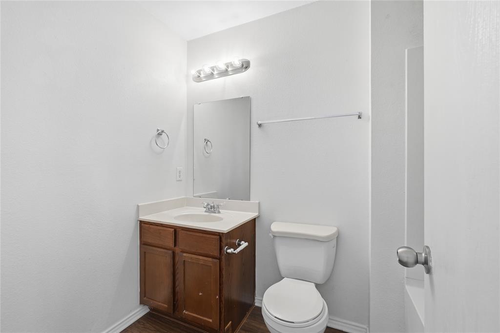 4005 Freedom Street Forney, TX 75126 - Photo 33 of 40 a bathroom with a toilet a sink and mirror