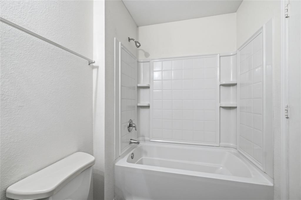 4005 Freedom Street Forney, TX 75126 - Photo 34 of 40 a bath room with a toilet and a bath tub