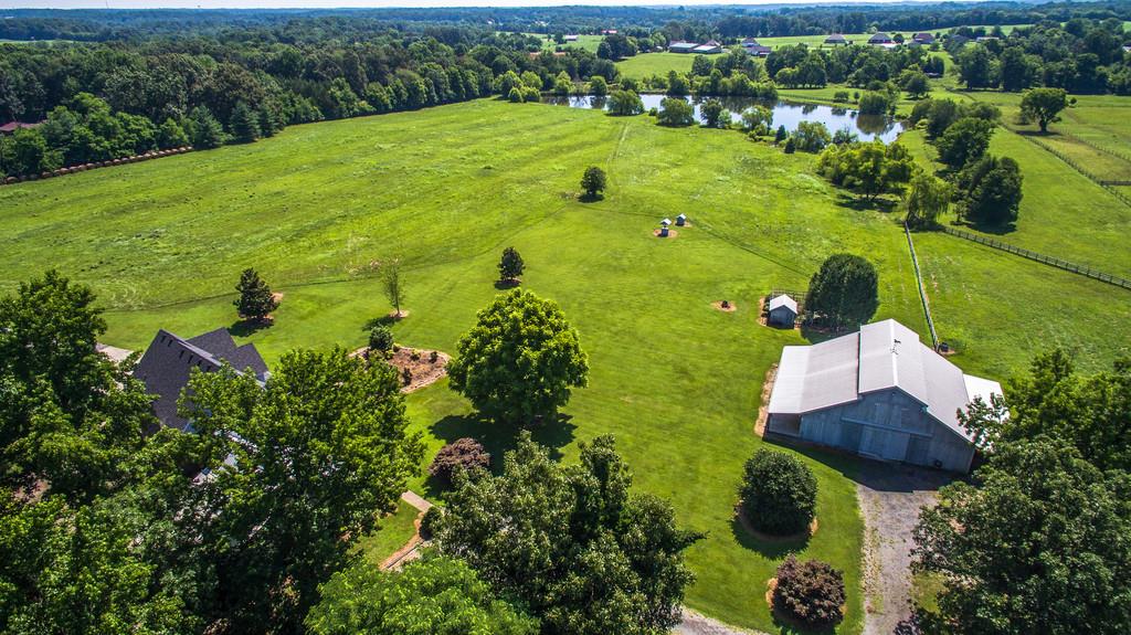 an aerial view of a house with a yard and lake view
