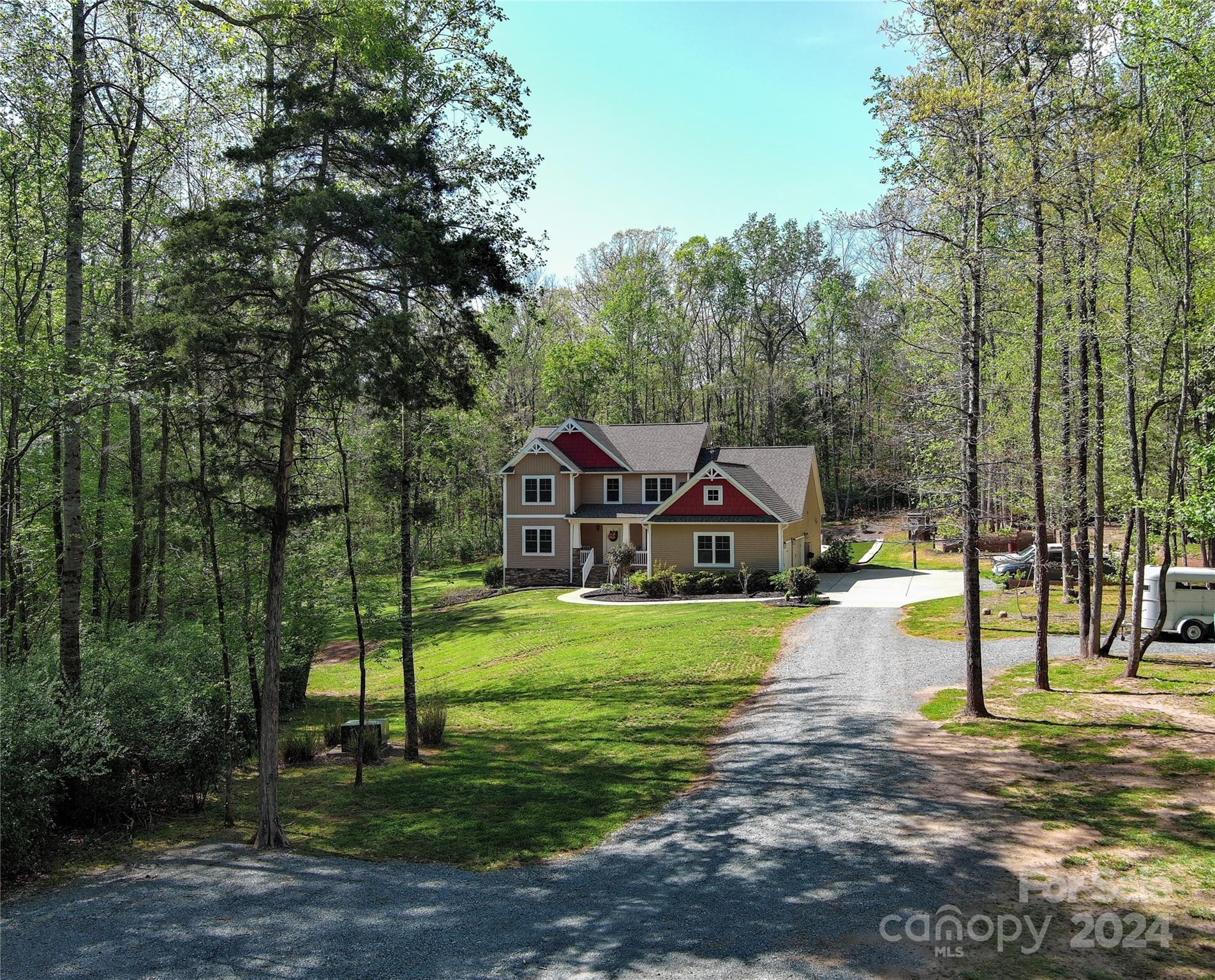 a front view of a house with a yard and trees