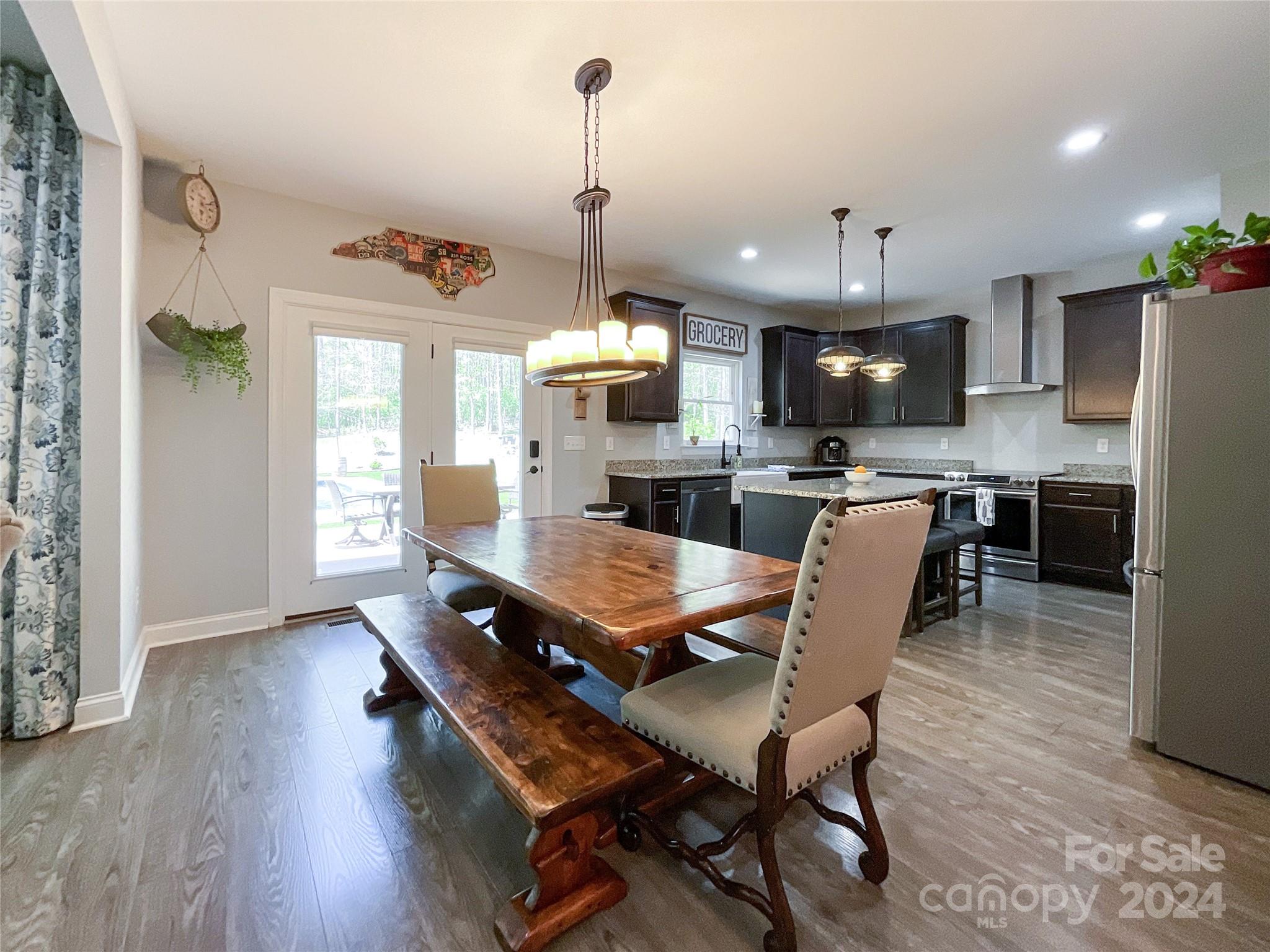 9408 Deer Run Road Waxhaw, NC 28173 - Photo 11 of 47 a dining room with stainless steel appliances kitchen island granite countertop a table chairs and a refrigerator