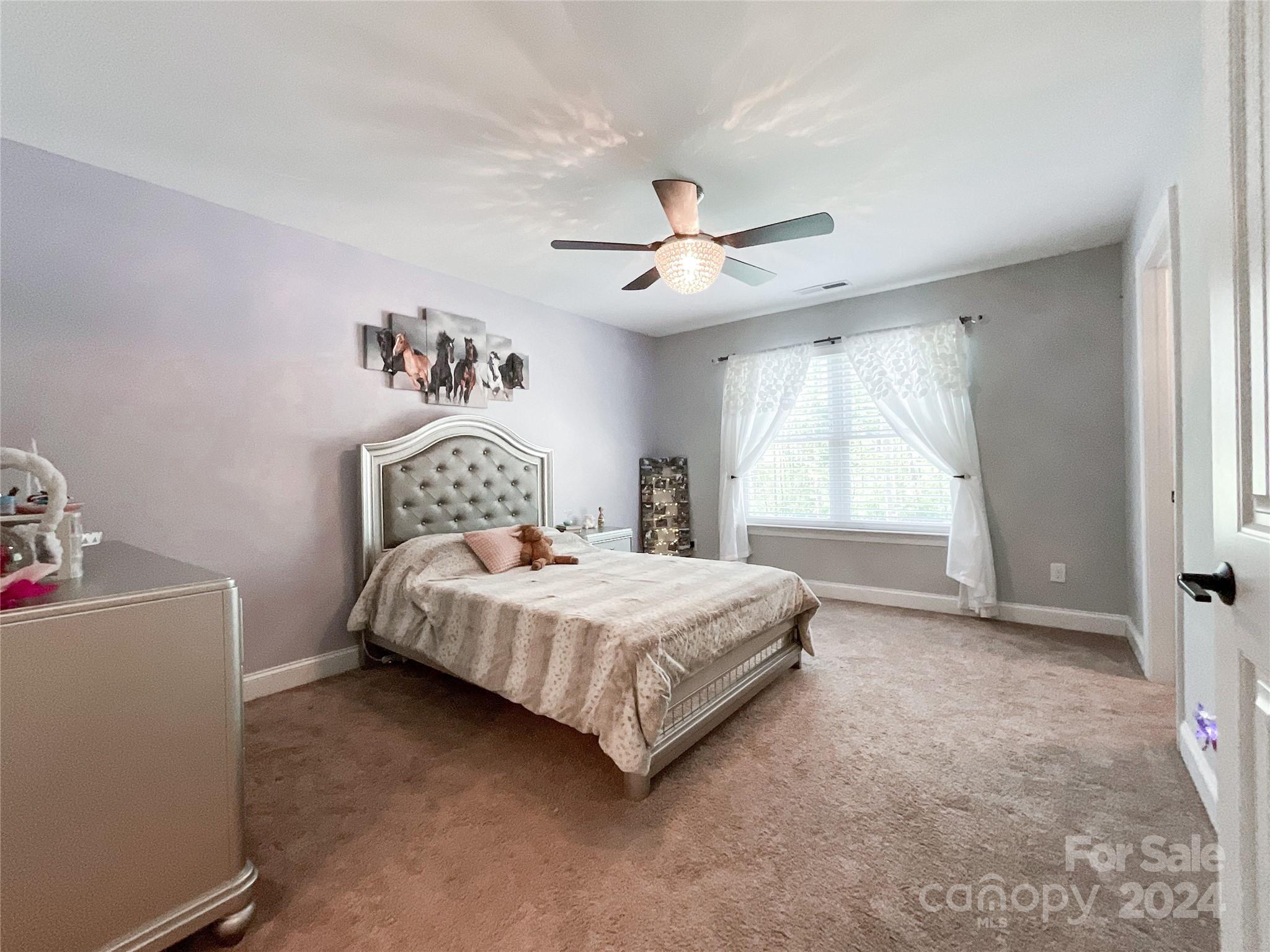 9408 Deer Run Road Waxhaw, NC 28173 - Photo 29 of 47 a bedroom with a bed chandelier and a window