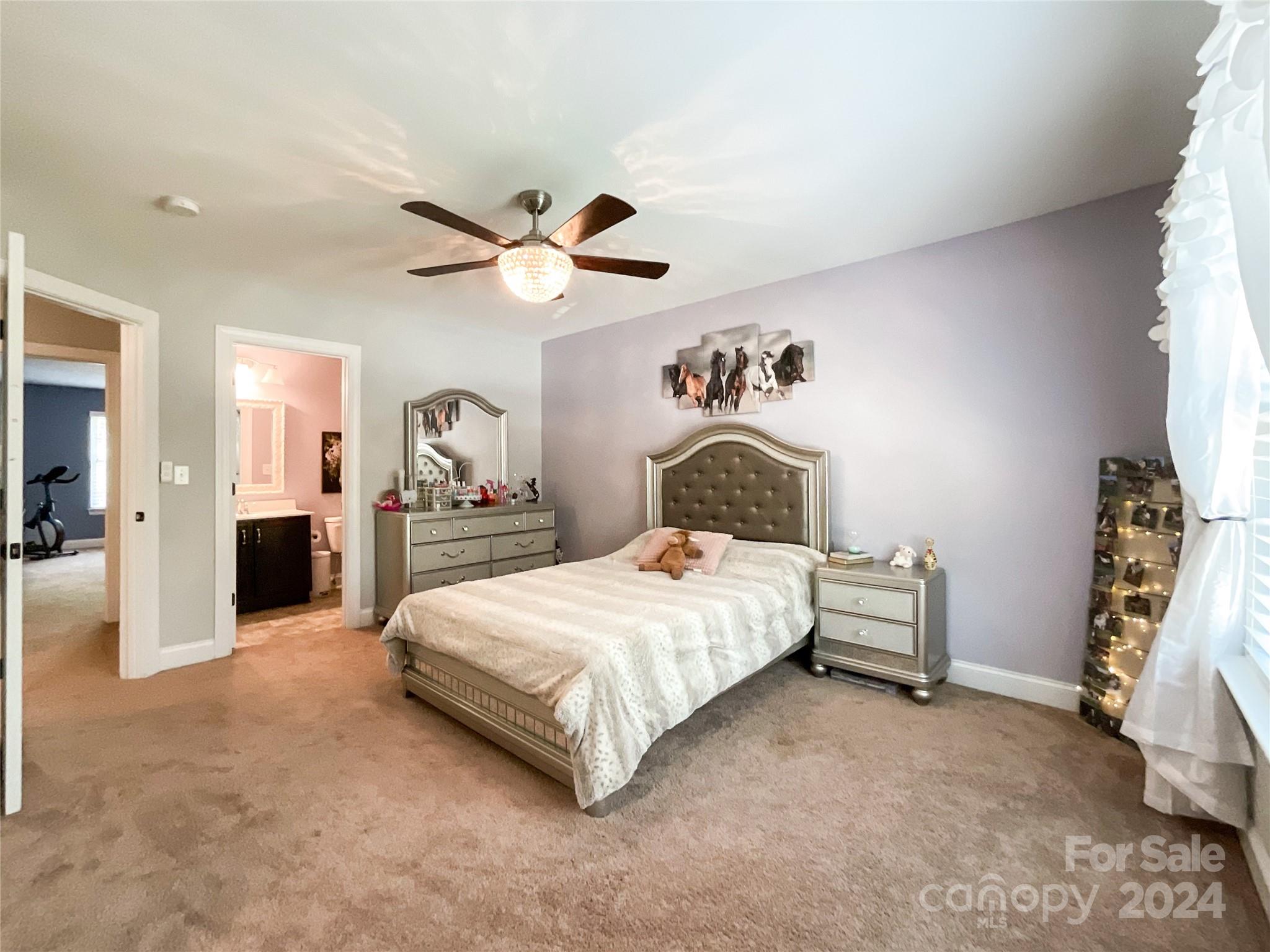 9408 Deer Run Road Waxhaw, NC 28173 - Photo 32 of 47 a spacious bedroom with a bed and a chandelier