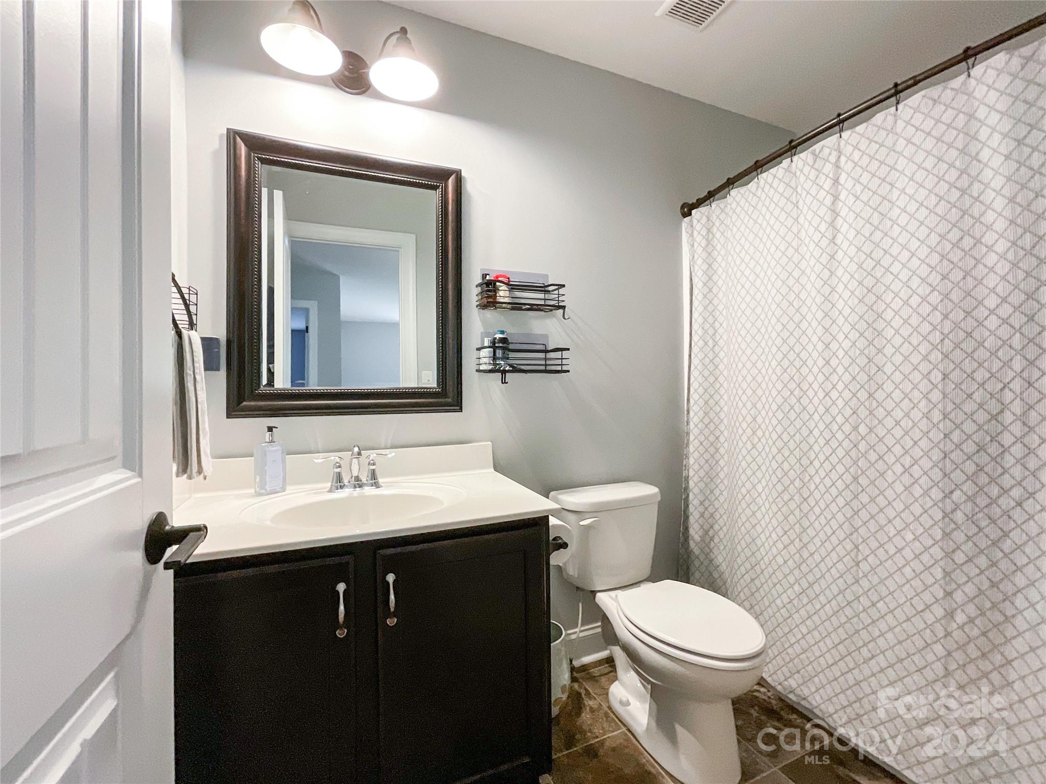 9408 Deer Run Road Waxhaw, NC 28173 - Photo 34 of 47 a bathroom with a toilet a sink and a mirror
