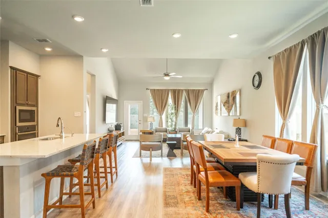 a dining room with stainless steel appliances granite countertop a table and chairs