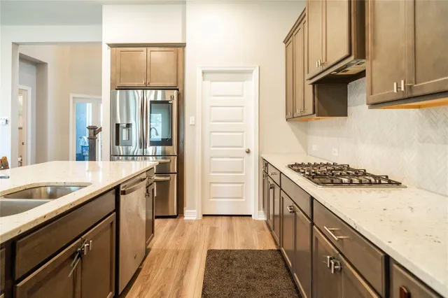 a kitchen with granite countertop a sink stove and cabinets