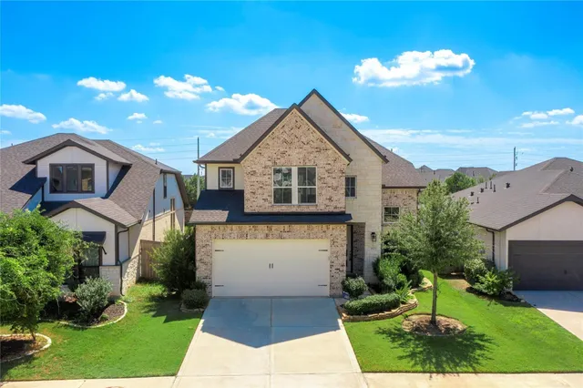 a front view of a house with a garden and yard