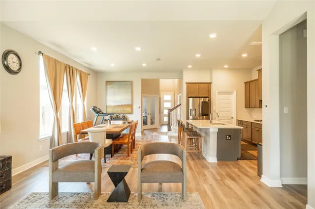 a living room with stainless steel appliances furniture cabinets and a wooden floor