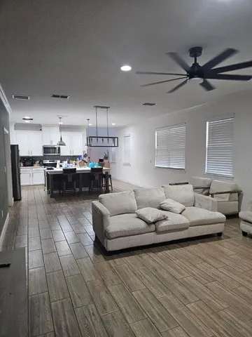 a living room with furniture and a wooden floor