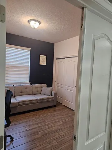 a living room with furniture and a wooden floor