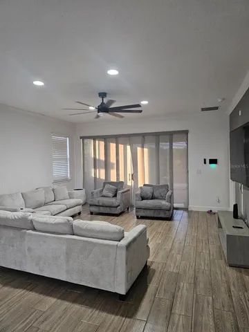 a living room with furniture and a wooden floor
