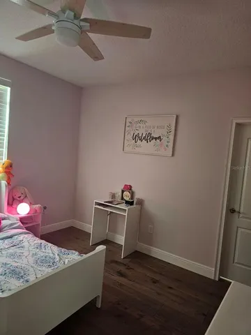 a room with a bed and wooden floor