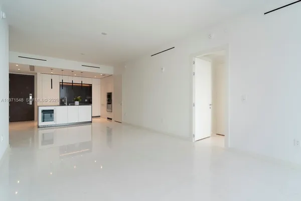 a view of empty room with kitchen