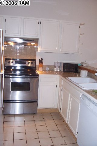 101 Hui Rd F, Unit F KIPA VILLAGE B2 Lahaina, HI 96761 - Photo 4 of 10 a kitchen with a stove top oven and cabinets
