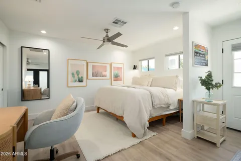 a bedroom with a bed chair and dresser