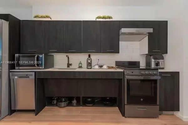 a kitchen with a sink cabinets and stainless steel appliances