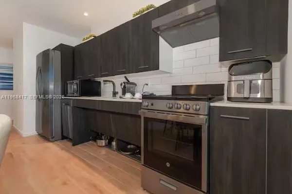 a kitchen with stainless steel appliances a stove a refrigerator and a sink