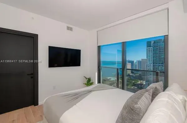 a bedroom with a bed and a flat screen tv