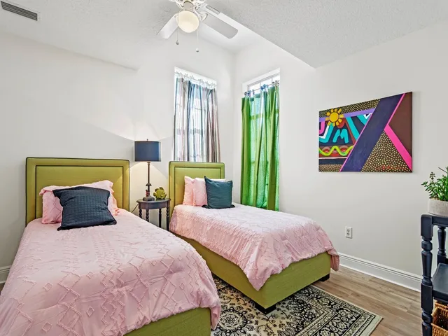 a bedroom with 2 bed and a painting on the wall