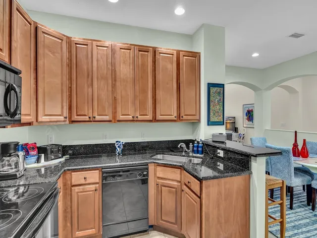 a kitchen with stainless steel appliances granite countertop a sink stove and cabinets