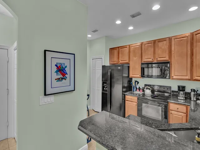 a kitchen with stainless steel appliances granite countertop a refrigerator a stove top oven a sink and dishwasher