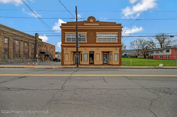 a front view of a building with a garden
