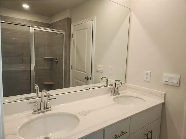 a bathroom with double vanity sinks and a mirror