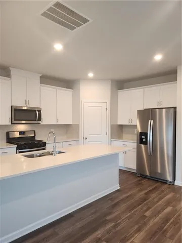 a kitchen with stainless steel appliances a refrigerator sink and microwave