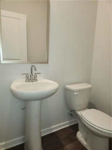 a bathroom with a sink toilet and a mirror