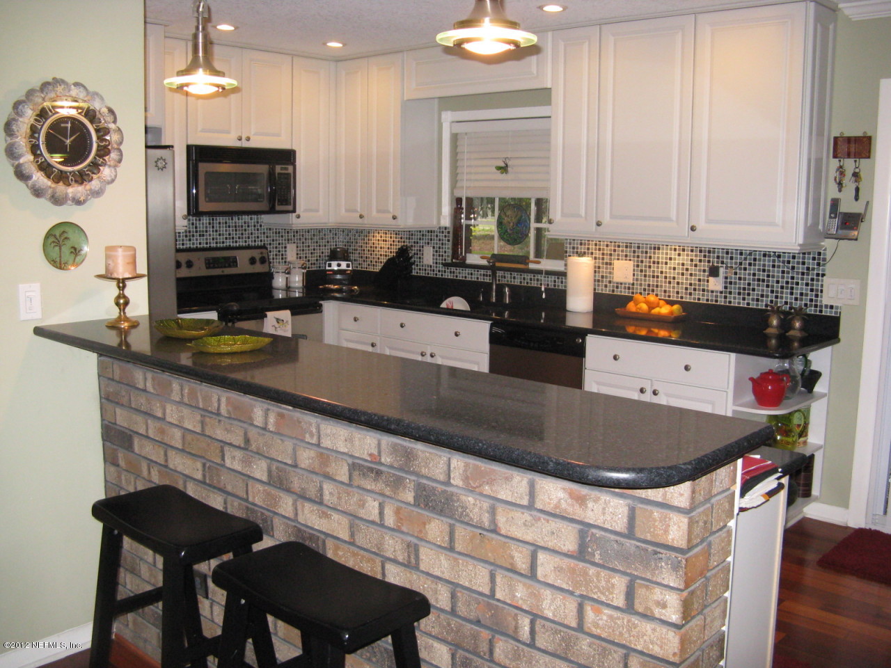 629 Segovia Road St. Augustine, FL 32086 - Photo 8 of 21 a kitchen with a stove a microwave and refrigerator