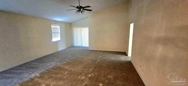 a view of a big room with windows and chandelier fan