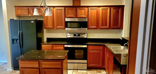 a kitchen with stainless steel appliances granite countertop a refrigerator stove and oven