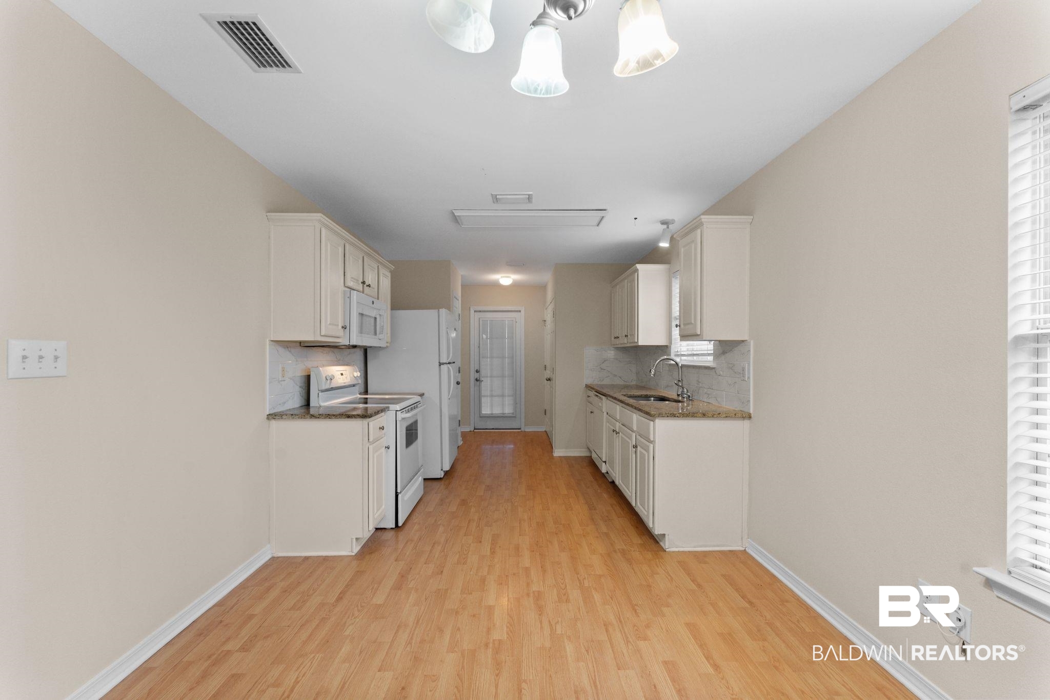 4009 Kendallbrook Loop Foley, AL 36535 - Photo 8 of 28 Kitchen with white appliances, tasteful backsplash, light wood-style floors, and white cabinets