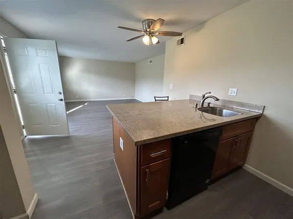a kitchen with a sink a counter space and cabinets