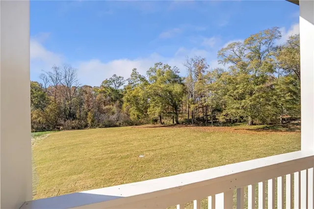 an empty room with wooden floor windows and ceiling fan
