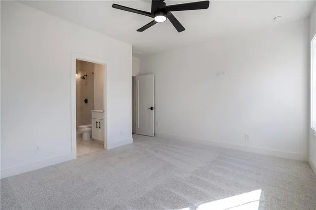 an empty room with windows and ceiling fan