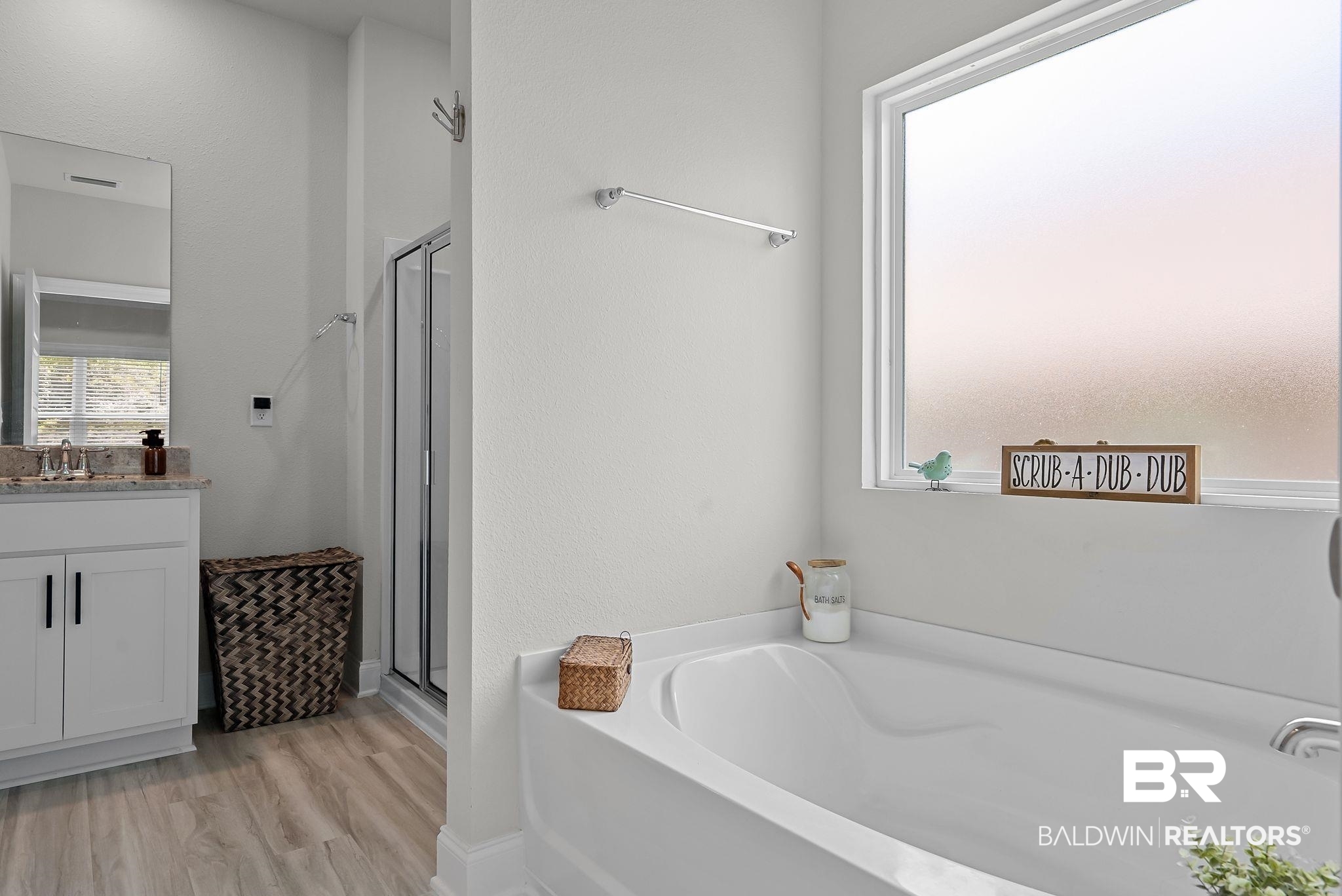 13966 Antler Hl Road Daphne, AL 36527 - Photo 16 of 44 Bathroom featuring a white soaking tub beneath a privacy window, a walk-in shower with a glass enclosure, and a single vanity with a stone-finish countertop and white cabinetry
