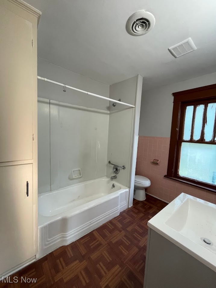 950 Avon Street Akron, OH 44310 - Photo 12 of 15 Full bathroom with toilet, visible vents, tile walls, and wainscoting