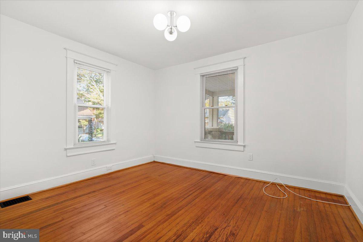 4302 30th Street Mount Rainier, MD 20712 - Photo 11 of 23 a view of an empty room with wooden floor and a window