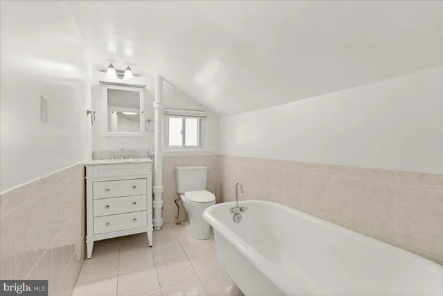 a bathroom with a bathtub sink and mirror