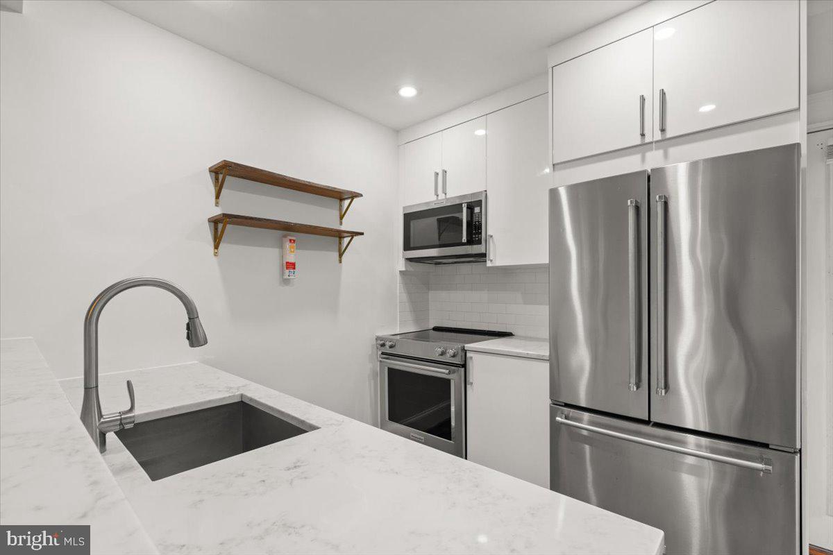 4302 30th Street Mount Rainier, MD 20712 - Photo 5 of 23 a kitchen with a refrigerator sink and microwave